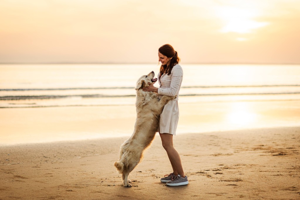 Laëtitia avec un Golden Retriever sur la plage au coucher du soleil